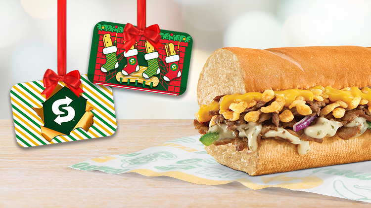 Six-inch Cheesy Garlic Steak with two Subway holiday gift cards hanging down from frame.