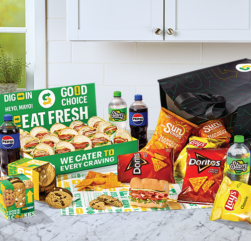 Subway® Catering subs, chips, cookies and Pepsi products on countertop.
