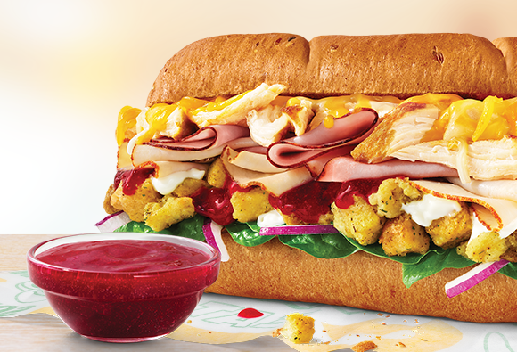 Sub de seis pulgadas TurHamKen junto a un ramequín de salsa de arándanos.